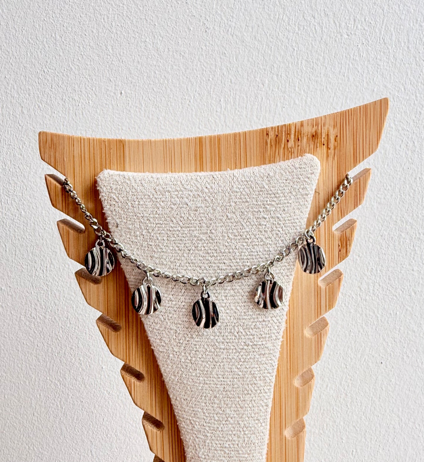 Chaîne de cheville argentée à breloques ondulées